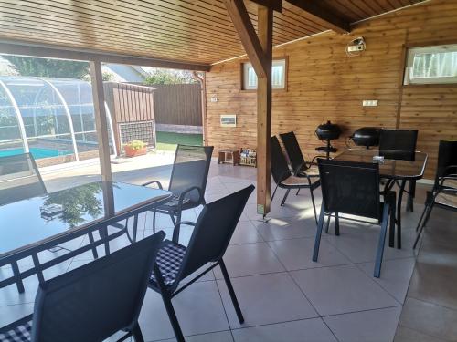 a patio with tables and chairs and a pool at Tengercsillag Vendégház in Alsóörs