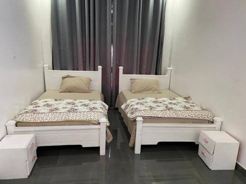 two beds sitting next to each other in a room at Khartoum Nights in Kigali
