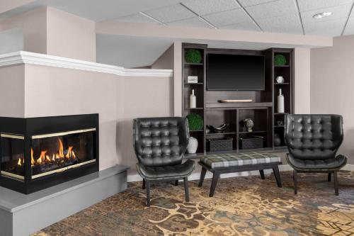 a living room with two chairs and a fireplace at Residence Inn by Marriott Albuquerque North in Albuquerque