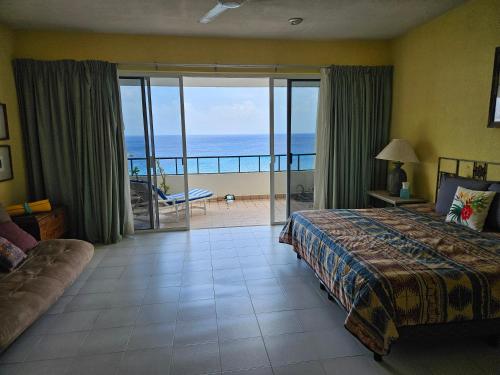 a bedroom with a bed and a view of the ocean at Cantamar 401, huge condo , incredible views, Sargassum Free in Cozumel
