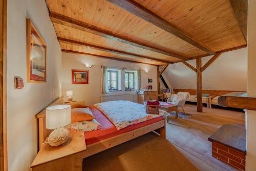 a bedroom with a large bed and a wooden ceiling at Apartmány Stodola in Malá Morávka