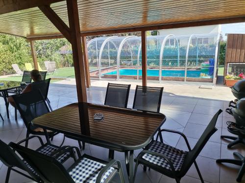 a patio with a table and chairs and a swimming pool at Tengercsillag Vendégház in Alsóörs