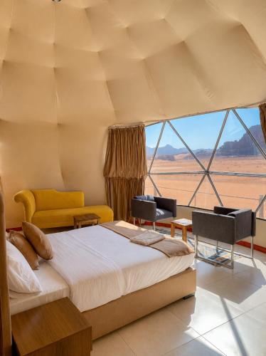 a bedroom with a bed and a view of the desert at Norita Luxury Camp in Wadi Rum