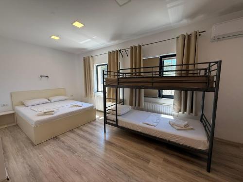 two bunk beds in a room with wooden floors at Greenstone Land - Corbu in Năvodari