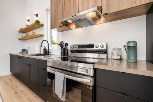 a kitchen with a stainless steel stove top oven at Modern Comfort - Spa - Mountain - Chalet KNOX in Saint Come