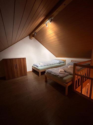 a attic room with two beds and a staircase at Big 3-bedroom flat with new kitchen in Brienz
