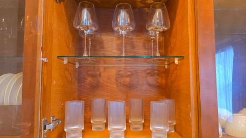 a group of glass wine glasses in a cabinet at Casa Näab Centro de Merida in Mérida