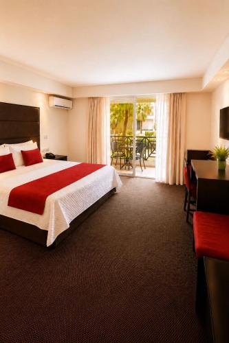a hotel room with a large bed and a table and chairs at Savoy Hotel Boutique in Las Terrenas