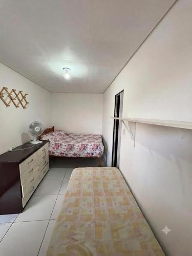 a small bedroom with a bed and a dresser in it at Casa de Temporada em Bezerros in Bezerros
