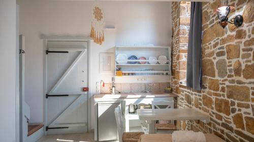 a kitchen with an open door and a table at Rodakas Rooms-Adigoni in LivadhokhÃ³rion