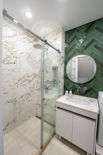 a bathroom with a shower and a sink and a mirror at 3-Room Seaview Apartment at Bamboo Beach in Ts'ikhisdziri