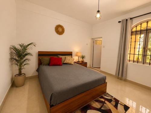 a bedroom with a bed and a potted plant at Ocean view in Pointe aux Biches