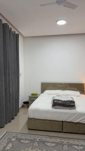 a bedroom with a large bed with black curtains at شقه مستقله بالقرب من مطار صلاله in Salalah