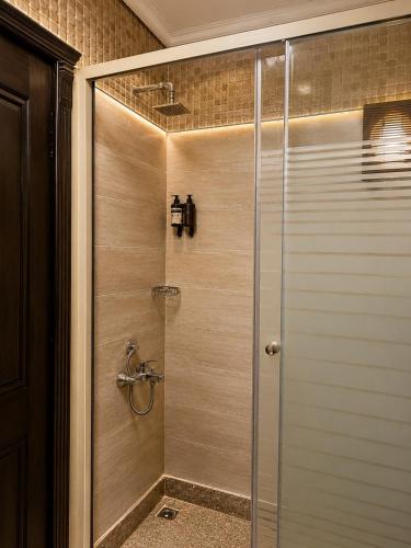 a shower with a glass door in a bathroom at El Amin Hotel & Suites - Downtown Cairo in Cairo