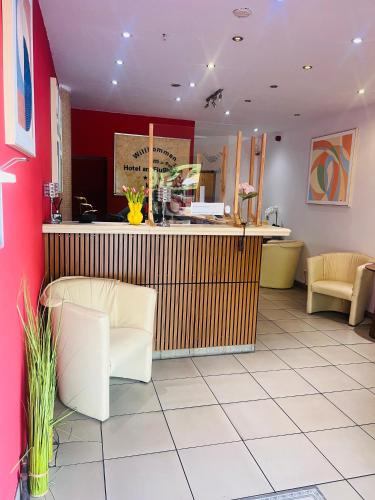 a restaurant with a counter and chairs in a room at Hotel Am Flughafen in Cologne