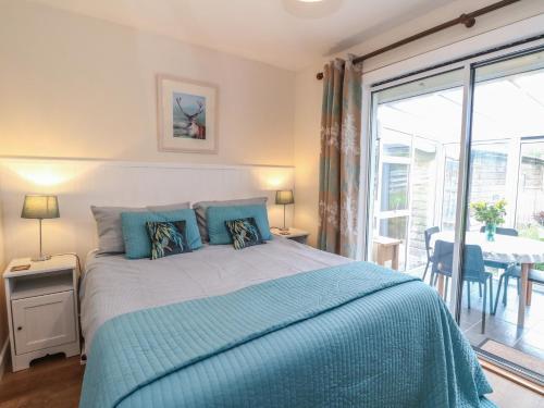 a bedroom with a bed with a blue comforter at Steam Cottage in Aviemore