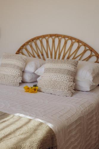 a bed with white pillows and yellow flowers on it at Origines Be Holistic in Brengues