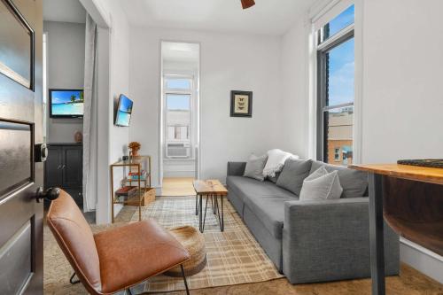 a living room with a couch and a tv at Downtown Palace Hotel Suite - Steps to Adventure in Salida