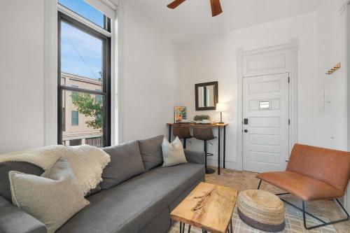 a living room with a gray couch and a window at Downtown Palace Hotel Suite - Steps to Adventure in Salida
