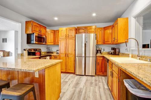 a kitchen with wooden cabinets and a stainless steel refrigerator at 4BR Downtown Basecamp - Walk to Everything in Salida