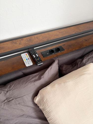 a bed with two remote controls on top of it at Le clos du landreau in Saint-Père-en-Retz