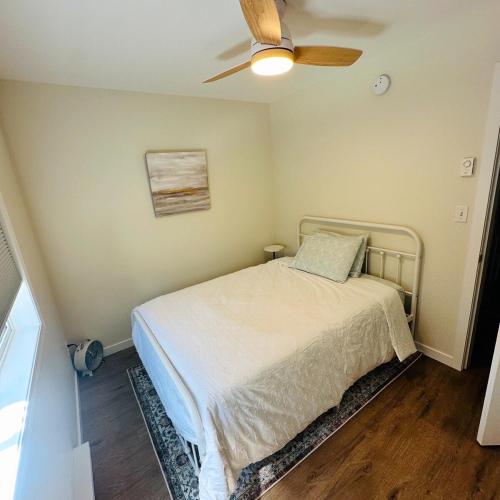 a bedroom with a bed with a ceiling fan at The Wineries are Calling! in Penticton