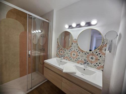 a bathroom with a shower and a sink and mirrors at Atria SILS in Caen