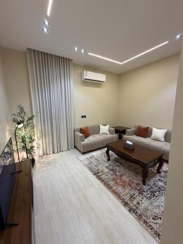 a living room with a couch and a coffee table at SORANO Apartments in Hail
