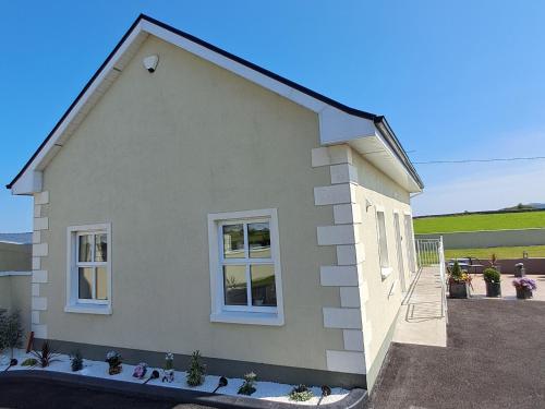 a house with two windows on the side of it at Warm Spacious Three Bed Chalet in Galway