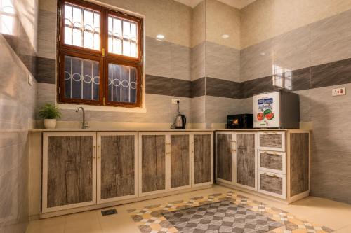 a kitchen with a sink and a window at Cozy Quarters in Zanzibar City