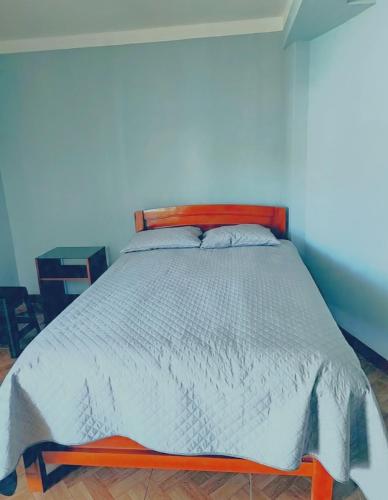 a bed with a wooden frame in a bedroom at El REFUGIO DE MIS SUEÑOS in Yungay