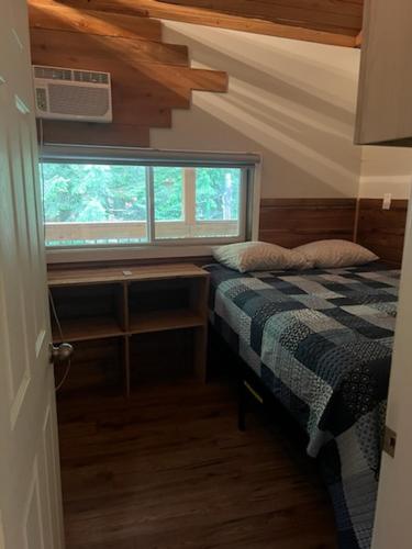 a small bedroom with a bed and a window at Noah's Ark Campground in Malakwa