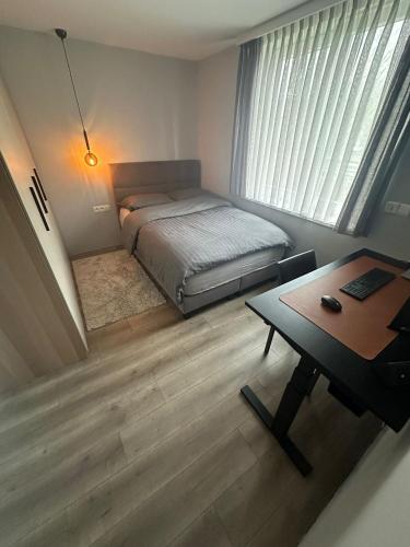 a small bedroom with a bed and a desk at Tomorowland Woning in Boom in Boom