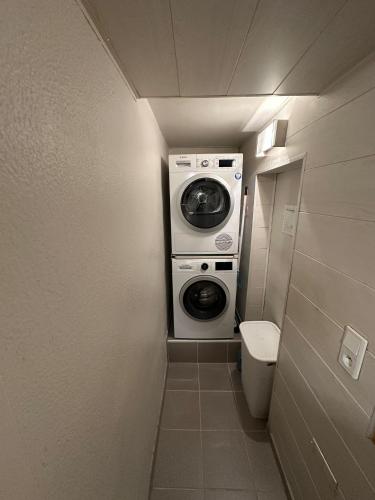 a small bathroom with a washing machine and a toilet at Tomorowland Woning in Boom in Boom