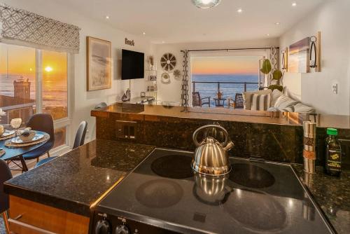 a kitchen with a stove and a view of the ocean at Sur La Mer, beachfront, tidal pools in San Diego