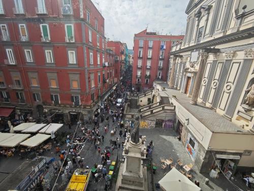 a crowd of people walking around a street in a city at San Gregorio Suite&Rooms in Naples