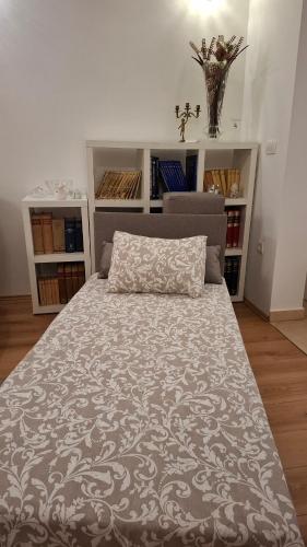 a large bed with a pillow on top of it at Apartman Natali in Buzdohanj