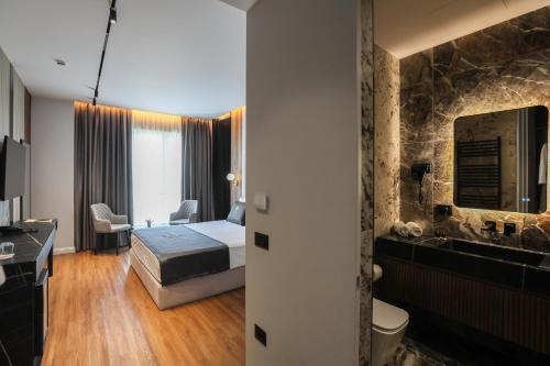 a hotel room with a bed and a bathroom at Luani-A spa & wellness center in Shkodër