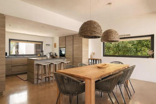 a kitchen and dining room with a wooden table and chairs at Sunset Sea View Villa with Private Pool in Sant Josep de sa Talaia