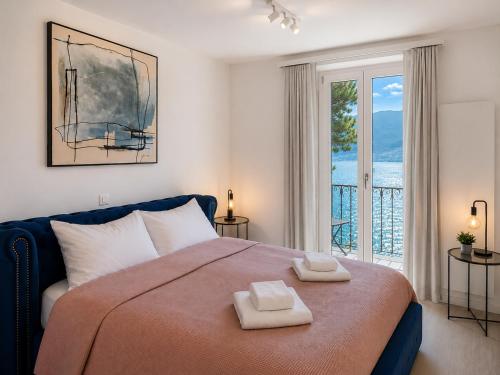 a bedroom with a large bed with two towels on it at Rivalago - Lake front apartment on Lake Promenade in Brissago