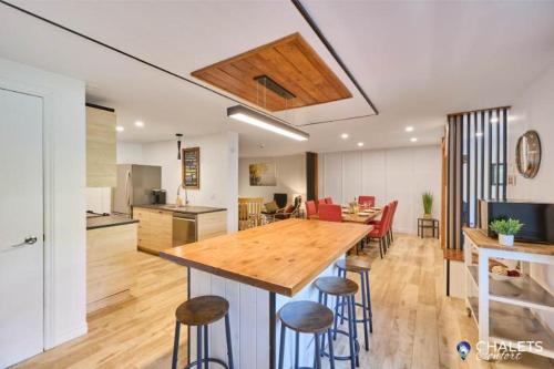 a kitchen and living room with a large wooden table at Le Rustique Moderne Detente - Lake Access in Pohénégamook