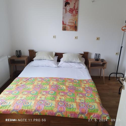 ein Schlafzimmer mit einem Bett, auf dem eine bunte Decke liegt in der Unterkunft Salvatori in Garić
