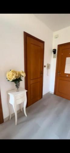 a vase of flowers on a table next to a door at Maison Sofia Mare in Silvi Marina