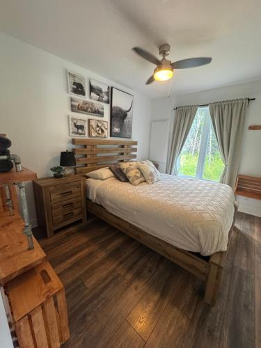 a bedroom with a bed and a ceiling fan at Le Béluga in Saint-Calixte
