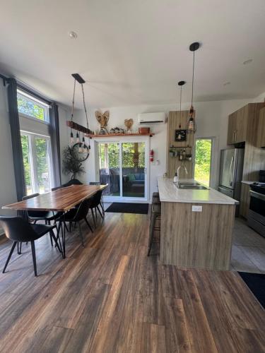 a kitchen and dining room with a wooden table at Le Béluga in Saint-Calixte