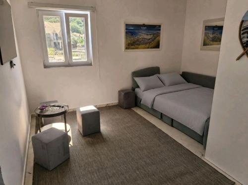 a small bedroom with a bed and a window at Apartman UNA in Bjelila