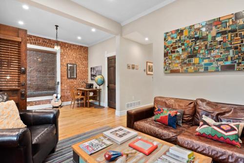 a living room with leather furniture and a brick wall at The Whittier Wonder in Denver