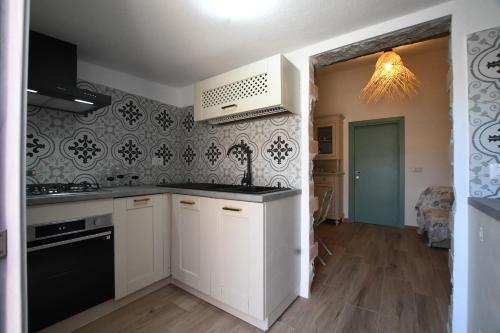 a kitchen with white cabinets and a black counter top at Stazzo Rosalba in Arzachena