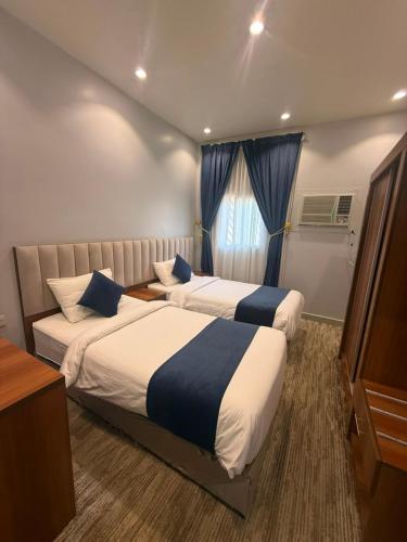 ein Hotelzimmer mit zwei Betten und einem Fenster in der Unterkunft لافيرا للشقق الفندقيه - Lavera Apartments in Al-'Ula