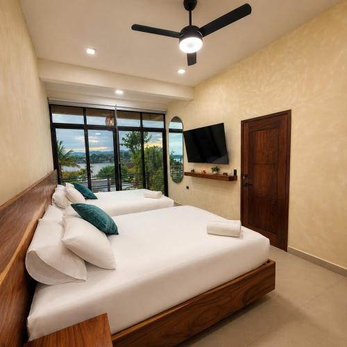 a bedroom with two beds and a flat screen tv at Itza Living Apartments in Flores